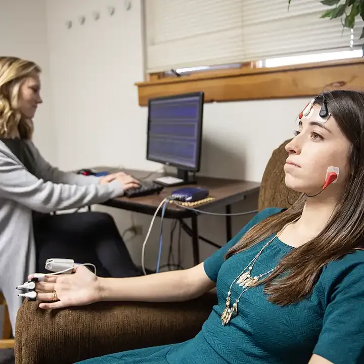 Female with her fingers hooked up to electronic monitoring.