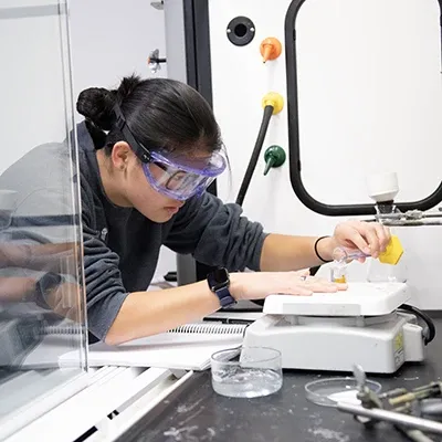 Student working in a lab with scientific equipment.